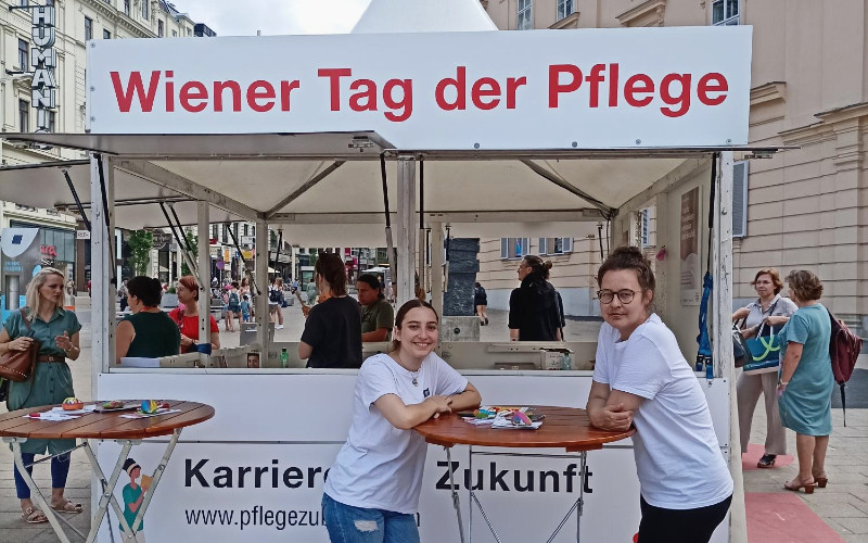 Zwei Studentinnen vor Infostand in Wien