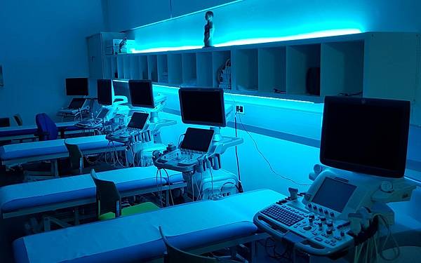 Monitore mit Ultraschallbildern in blau ausgeleuchtetem Raum