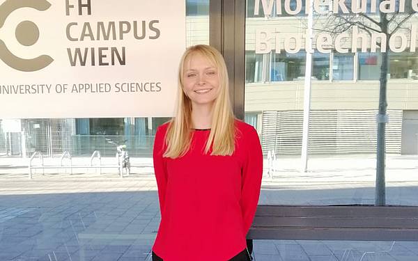 Die Absolventin Samantha Vanessa Göber steht vor dem Gebäude am FH-Standort Vienna BioCenter, wo die Studiengänge Molekulare Biotechnologie angesiedelt sind.
