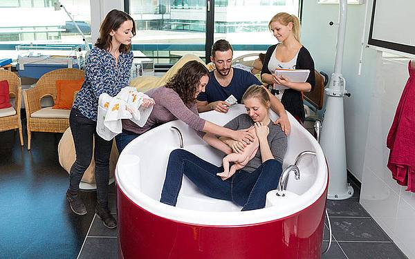 Studierende sind im Funktionsraum: Eine Studierende sitzt in der Geburtswanne