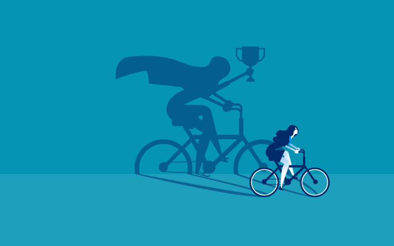 Person auf Fahrrad, Schatten zeigt SuperheldInnenenumhang