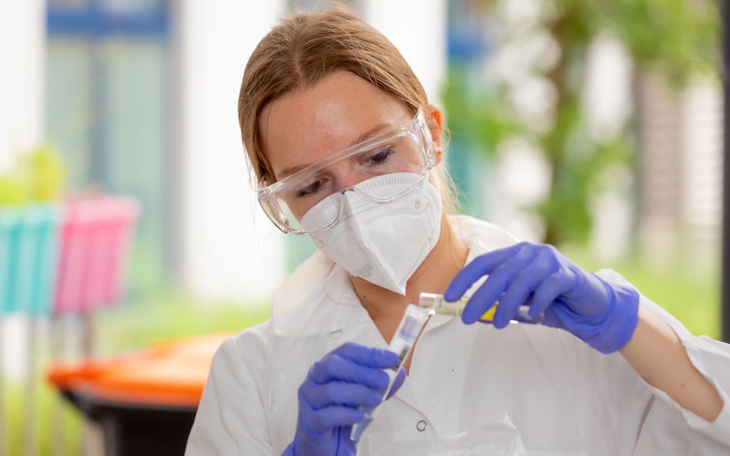 Studierende mit Handschuhen, Schutzmaske und Schutzbrille