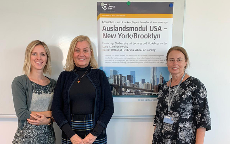 Anja Patschka, Peggy Tallier, Sabine Schweiger vor dem Plakat, auf dem Information und Brooklyn Bridge zu sehen sind.