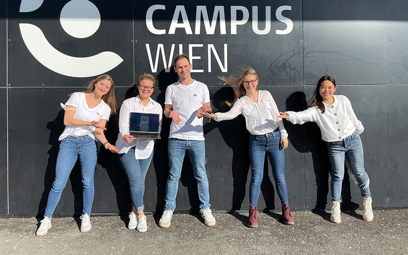 Studierendengruppe steht mit ihren Projekten vor dem Haupteingang der FH Campus Wien
