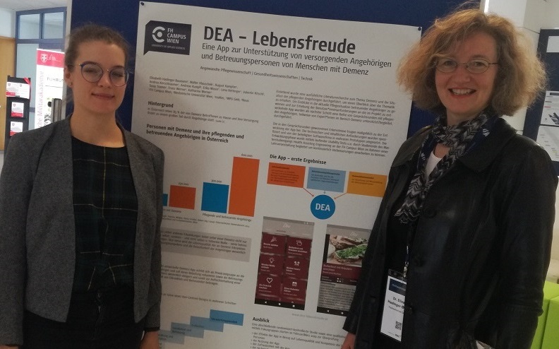 Frau Lucia Zeuner und Frau Ellisabeth Haslinger-Baumann vor dem DEA _ Lebensfreude-Poster