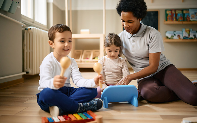 Pädagogin spielt mit zwei Kindern